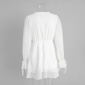 Detail of white chiffon dress showing elastic waist, ruffled sleeves and layered hem
