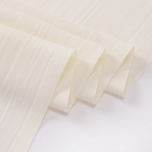 Macro shot of high-quality beige textile fabric showing fine texture and soft folds