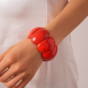 Close-up of oversized red acrylic geometric cuff bracelet worn on a female wrist