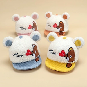 Detail of four soft fleece baby caps in pink, blue, orange, and yellow with embroidery