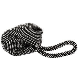 Close-up of a luxury black evening clutch bag featuring a knotted handle and silver rhinestones
