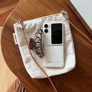 Canvas crossbody bag with Simple Wish label and leather strap on wooden surface