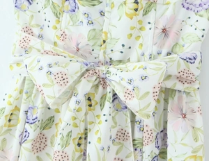 Détail d'une robe à imprimé floral avec un nœud à la taille et une couture soignée