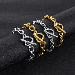 Macro detail of gold and silver OT buckle bracelets with thick rope chain on a stand