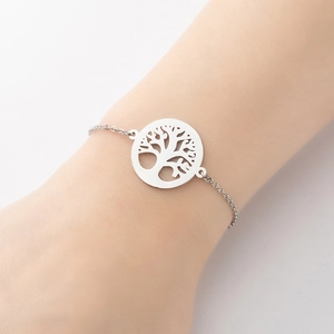 Close-up of minimalist stainless steel bracelet featuring a Tree of Life cutout charm