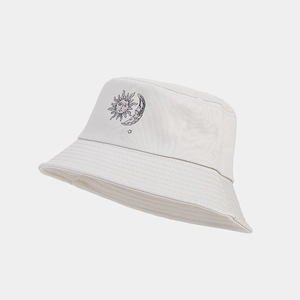 Dettaglio della stampa sole e luna su un cappello a secchiello in cotone color crema