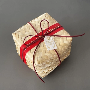 Detail of square bamboo gift box with red ribbon and thank you tag decoration