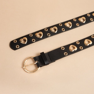 Detail of black punk leather belt featuring golden heart grommets and circular buckle