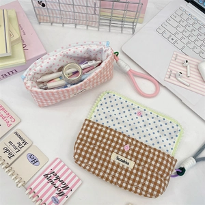 Close-up of quilted cotton pencil cases with polka dot lining and rope zipper pull