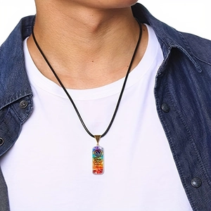 Modello maschile con collana pendente rettangolare ai sette chakra su cordino nero