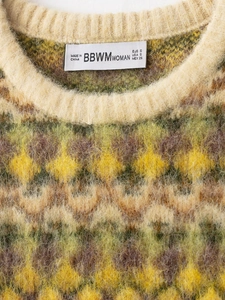 Macro view of argyle pattern knit sweater with fuzzy mohair texture and ribbed neckline