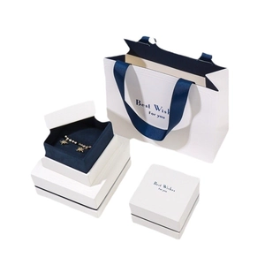 Star-shaped gold earrings set with sparkling stones in premium white gift packaging
