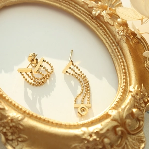 Vintage 18k gold triple layered bead chain tassel earrings on a decorative frame