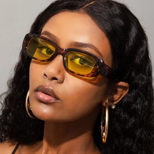 Close-up of vintage rectangle tortoiseshell sunglasses with yellow tinted lenses on model