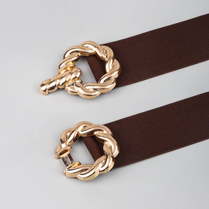Close-up of brown elastic waist belts featuring gold braided metal interlocking buckles