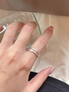Detail of S925 sterling silver leaf and crown ring on hand with soft elegant lighting