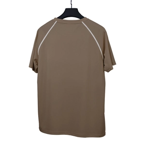 Gros plan du T-shirt de sport marron montrant les coutures blanches et le tissu technique