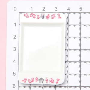 Miniature white rectangular dollhouse tray with pink dot patterns on a measuring mat