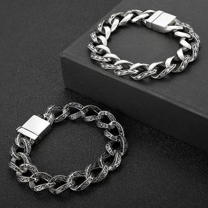 Close-up of vintage silver Cuban links with intricate black engravings and square clasp
