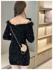 Chic model wearing a gold shell-shaped metal evening bag with a dainty chain strap