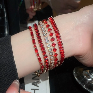 Close-up of five-piece 18k gold plated bracelet set with ruby red and white zircon crystals