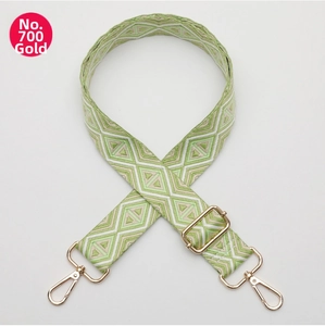 Detail of adjustable green geometric strap with gold hooks for crossbody bags