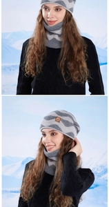 Close-up of winter knit hat and neck warmer set with wavy stripes in snowy mountains