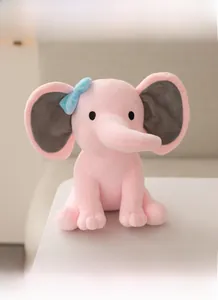 Detailed close-up of a pink plush elephant toy with soft fabric texture and a blue bow