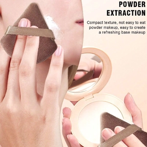 Detail view of triangular brown makeup sponge puff showing smooth powder application on face