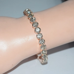 Detailed close-up of a rose gold tennis bracelet featuring single row sparkling crystals