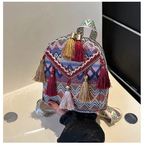 Detailed shot of ethnic woven backpack featuring colorful tassels and geometric patterns
