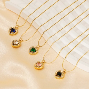 Close-up of gold heart pendant necklaces featuring five vibrant gemstone colors on silk