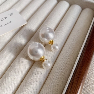 Vue détaillée de boucles d'oreilles vintage avec perles double face et touches dorées
