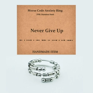 Detail view of Morse Code anxiety ring in 316L stainless steel with Never Give Up card