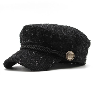 Detail of black tweed baker boy hat with gold vintage button and shimmering metallic thread