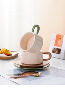 Detail von Nordischen Keramik-Kaffeetassen in Creme mit Oliven- und Karamell-Akzenten