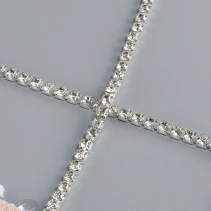 Detail der Silberkette mit quadratischen Strasssteinen auf pinkfarbenem Paillettenkleid