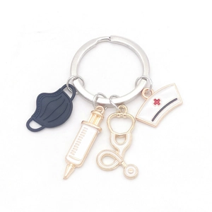Creative medical keychain with syringe, stethoscope and nurse hat charms on white background