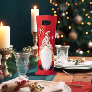 Detail of red Christmas gnome wine bottle cover with sequins on a festive table