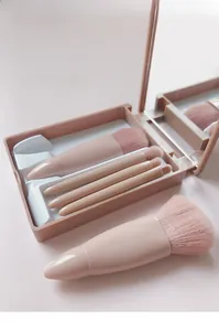 Detail of 5-piece portable pink makeup brush set with a built-in mirror storage box