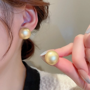 Minimalist matte gold spherical earrings with geometric design for women on model