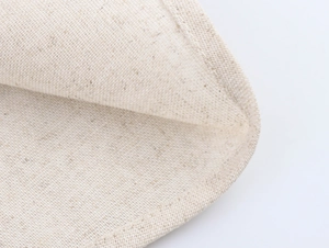 Gros plan détaillé sur la texture en lin beige et les coutures d'une jupe longue trapèze