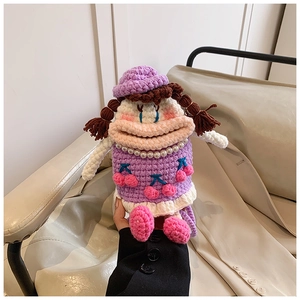 Close-up of handmade purple crochet bag with big mouth doll design and cherry pattern