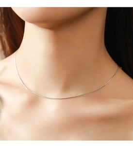 Detail view of a minimalist S925 sterling silver heart snake chain necklace on model