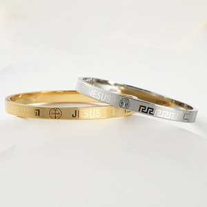 Detail view of gold and silver Jesus bracelets with Greek fret patterns and matte finish