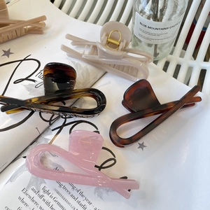 Detailed close-up of large acrylic claw clips in various tortoiseshell and pastel colors