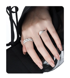 Detail of S925 silver wave ring with blue sapphire and matte finish band on finger