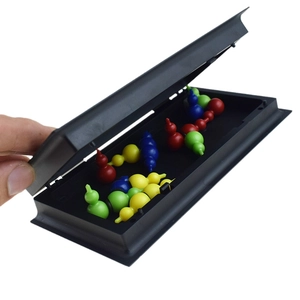 Detail of colorful resin pawn pieces inside a black folding magnetic ludo board game case