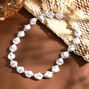 Detail of baroque pearl necklace with gold beads on a warm brown background
