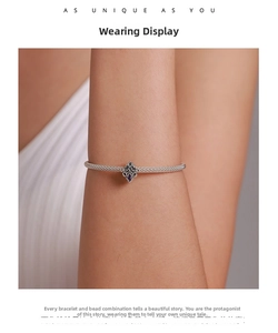 Close-up of Milanese mesh bracelet with vintage charm and purple cubic zirconia gemstone